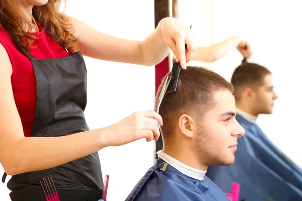 Belle fille coiffeur coupe gars dans le salon de beauté — Photo