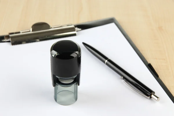 Stamp and clipboard on table — Stock Photo, Image