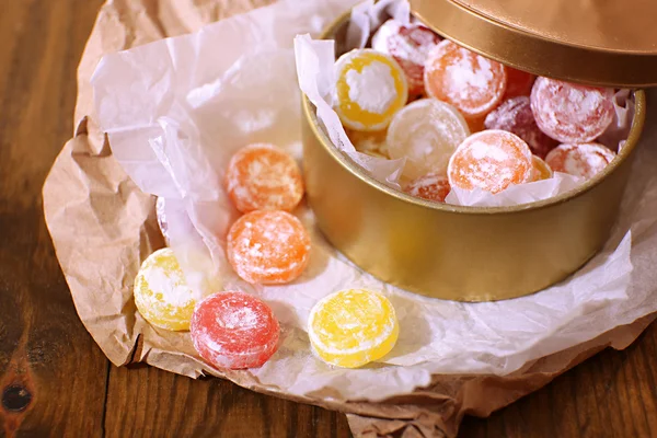 Sweet candies in metal can, on wooden background — Stock Photo, Image