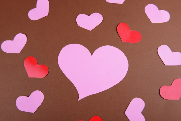 Бумажные сердца на коричневом фоне — стоковое фото