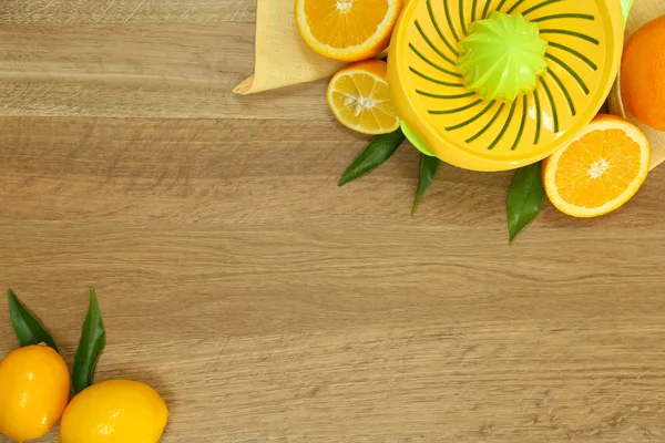 Prensa de cítricos y frutas sobre fondo de madera —  Fotos de Stock