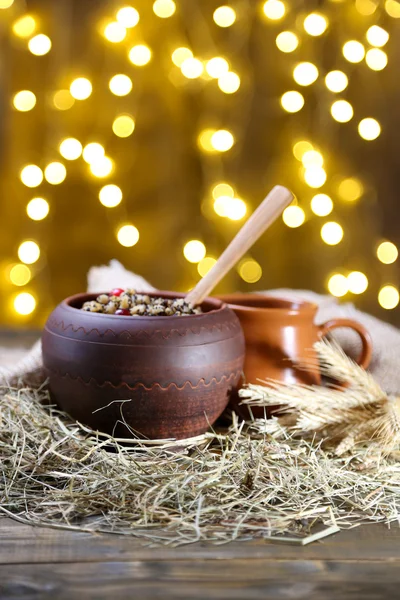 Pot with kutia - traditional Christmas sweet meal in Ukraine, Belarus and Poland, on wooden table, on bright background — Stock Photo, Image