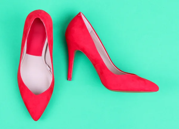 Beautiful red female shoes, on green background — Stock Photo, Image