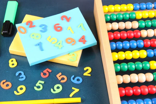 Barevné čísla, abacus, knihy a značky na školní stůl pozadí — Stock fotografie