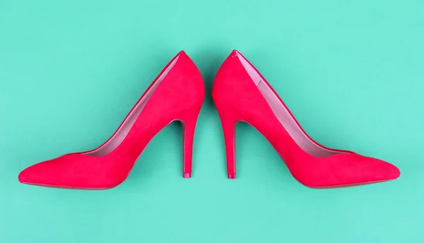 Vackra röda kvinnligt skor, på grön bakgrund — Stockfoto