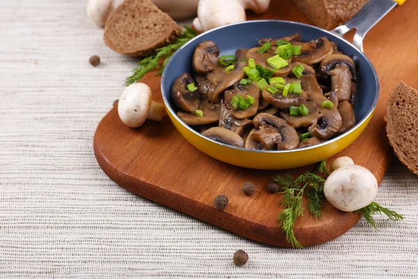 Deliciosos cogumelos fritos na panela na mesa close-up — Fotografia de Stock
