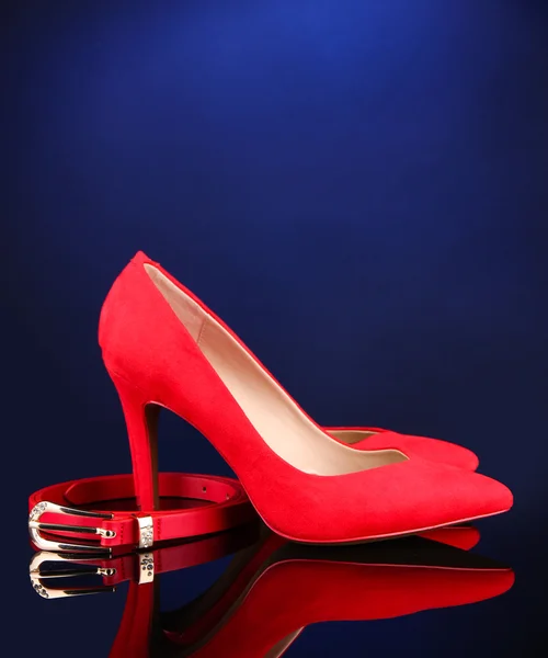 Beautiful red female shoes and belt, on blue background — Stock Photo, Image