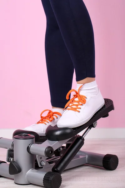 Donna che fa esercizio fisico sul passo. Primo piano sulle gambe . — Foto Stock
