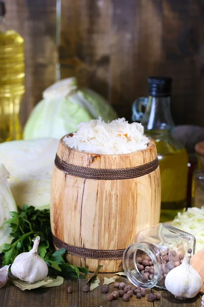 Samenstelling met vers en gemarineerde kool (zuurkool) in houten vat, op houten tafel achtergrond — Stockfoto