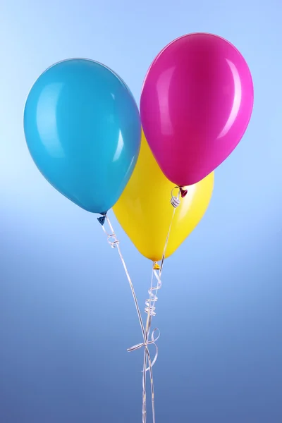 Trois ballons colorés sur fond bleu — Photo