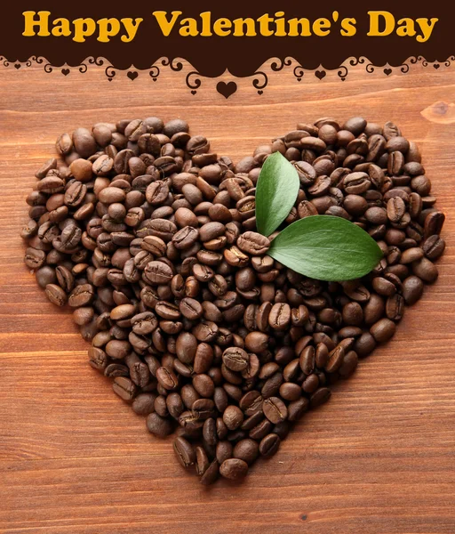 Kaffebönor med blad på trä bakgrund — Stockfoto