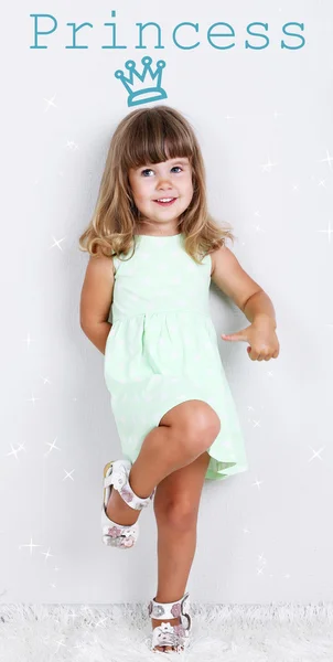 Little cute girl on carpet, on gray background — Stock Photo, Image