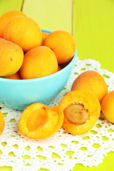 Fresh natural apricot in bowl on green wooden table — Stock Photo, Image