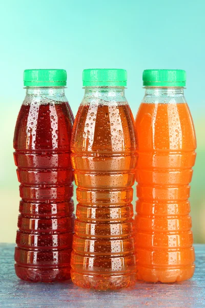 Assortiment van flessen met smakelijke vruchtensappen op lichte achtergrond — Stockfoto