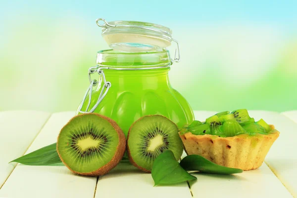 Jar of jam kiwi on wooden table on natural background — Stock Photo, Image