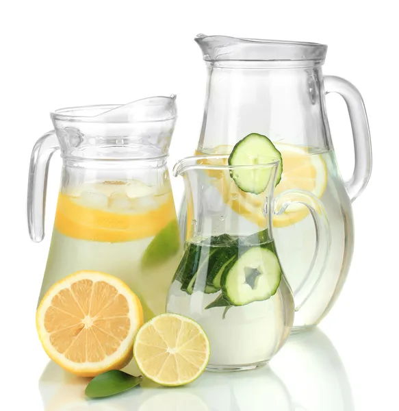 Água fria com limão, pepino e gelo em jarros isolados em branco — Fotografia de Stock