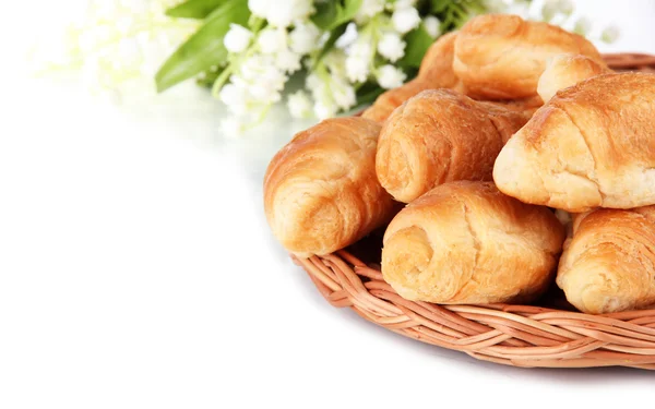 Croissants saborosos em esteira de vime isolado em branco — Fotografia de Stock