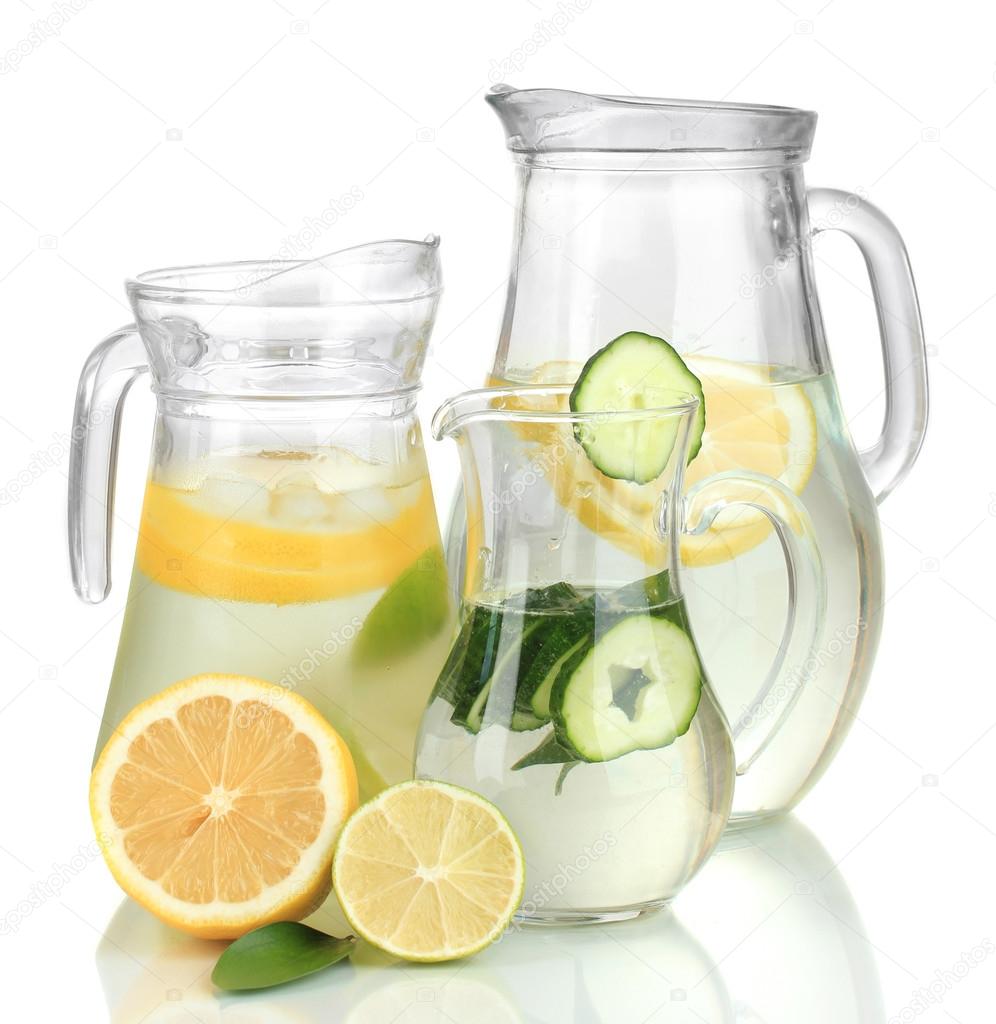 Cold water with lemon, cucumber and ice in pitchers isolated on white