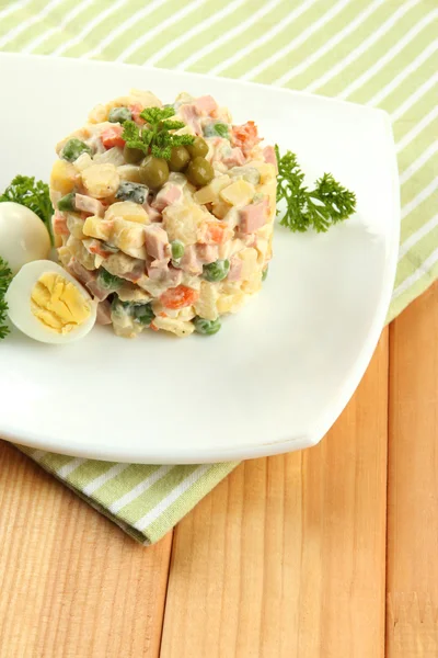 Salada tradicional russa Olivier, em guardanapo de cor, em fundo de madeira — Fotografia de Stock