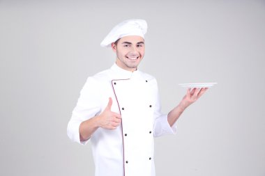 beyaz üniforma ve gri arka plan üzerine şapka profesyonel şef