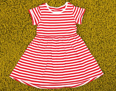 Yeşil halı üzerinde küçük kız için güzel bir elbise