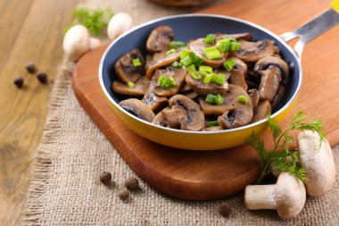 Masanın üzerinde tavada kızartılmış mantarlar.