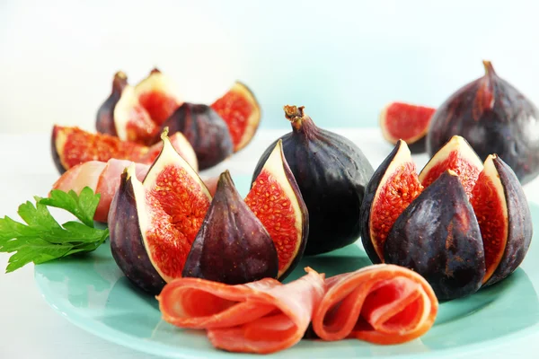 Tasty figs with ham on table — Stock Photo, Image