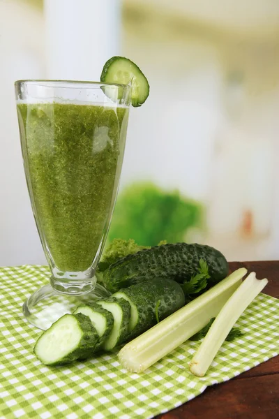 Glas van groene groentesap en groenten op houten tafel op lichte achtergrond — Stockfoto