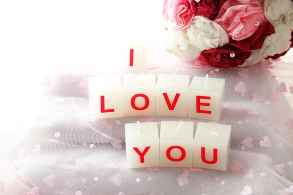 Candles with printed sign I LOVE YOU, on light background — стоковое фото