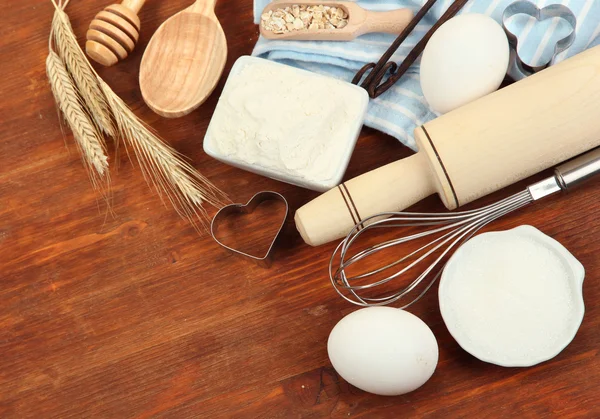 Concetto di cucina. Ingredienti di cottura di base e utensili da cucina su tavola di legno — Foto Stock