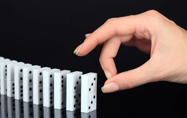 Hand pushing dominoes isolated on black — Stock Photo, Image