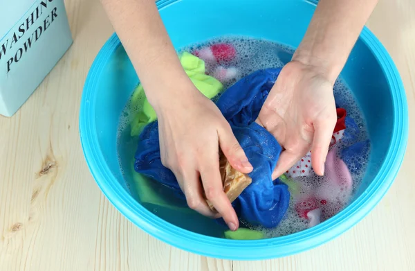 Hand washing in plastic bowl on wooden table close-up — Stock Photo, Image