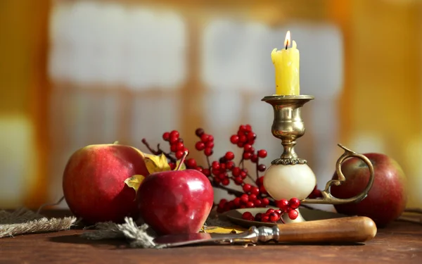 Composizione con mele e candela su tavolo in legno su fondo stanza — Foto Stock