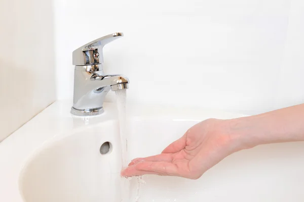 Nahaufnahme menschlicher Hände, die unter dem Wasserhahn im Badezimmer gewaschen werden, isoliert auf weiß — Stockfoto