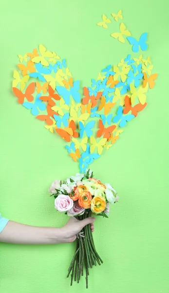 Paper butterflies fly out of flowers on green wall background — Stock Photo, Image