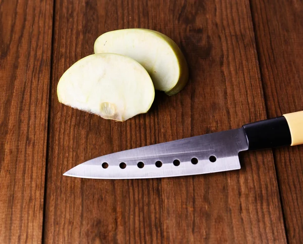 Keukenmes en groene appel, op houten ondergrond — Stockfoto