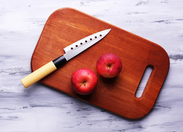 Μαχαίρι κουζίνας και κόκκινο μήλο, σε ξύλινο φόντο — Φωτογραφία Αρχείου