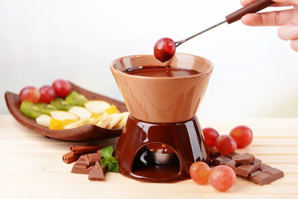 Çikolata fondü meyve üzerinde açık renkli ahşap tablo — Stok fotoğraf