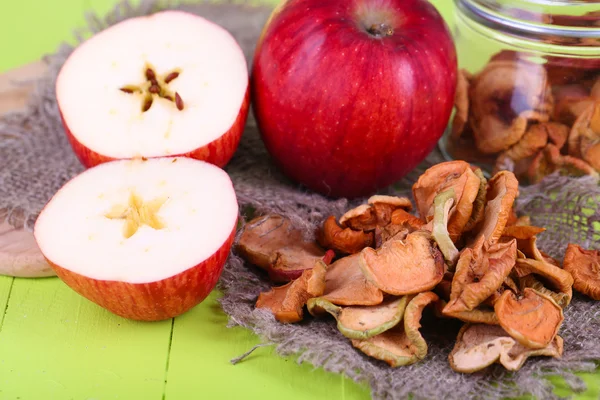 Gedroogde appels in glazen pot, op een houten achtergrond kleur — Stockfoto