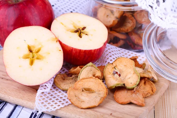 Manzanas secas en tarro de vidrio, sobre fondo de madera de color —  Fotos de Stock