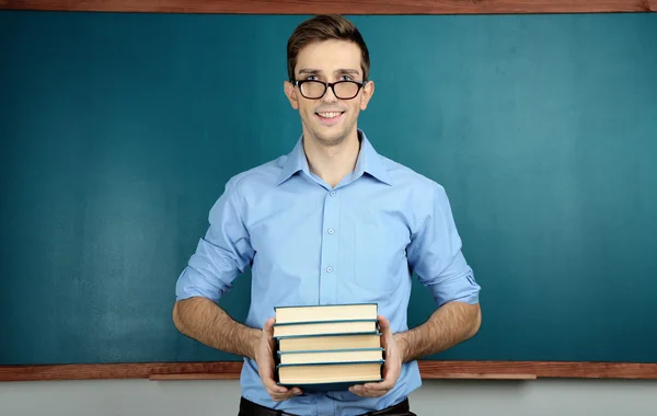 Jonge leraar in de buurt van schoolbord in school klas — Stockfoto