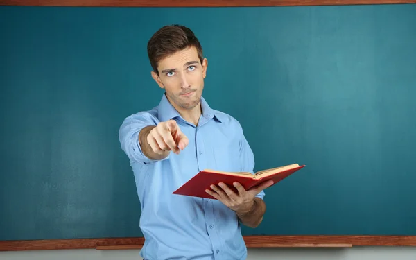 Young teacher near chalkboard in school classroom — Stock Photo, Image