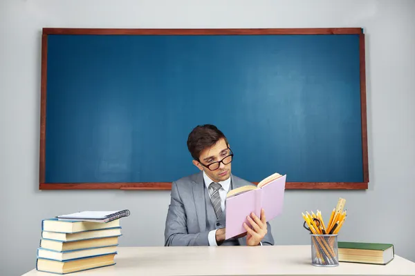 Young teacher sitting in school classroom — Stock Photo, Image