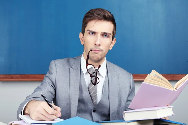 Young teacher sitting in school classroom — Stock Photo, Image