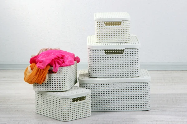 Plastic baskets with things in floor on room background — Stock Photo, Image