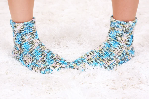 Female legs in colorful socks on white carpet background — Stock Photo, Image