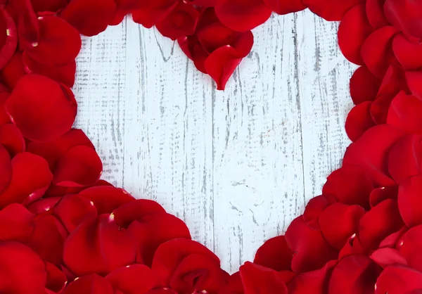 Hermoso corazón de pétalos de rosa roja en primer plano mesa de madera — Foto de Stock