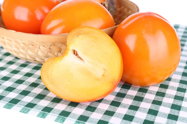 Ripe persimmons in wicker basket on table close-up — Stock Photo, Image