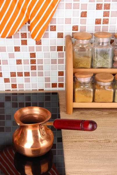 Maceta en la estufa en la cocina en la mesa en el fondo de mosaico azulejos — Foto de Stock