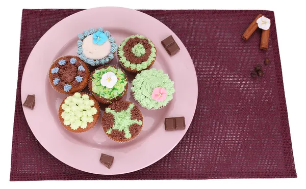 Cupcakes saborosos com creme de manteiga, no prato, no guardanapo colorido. isolado em branco — Fotografia de Stock